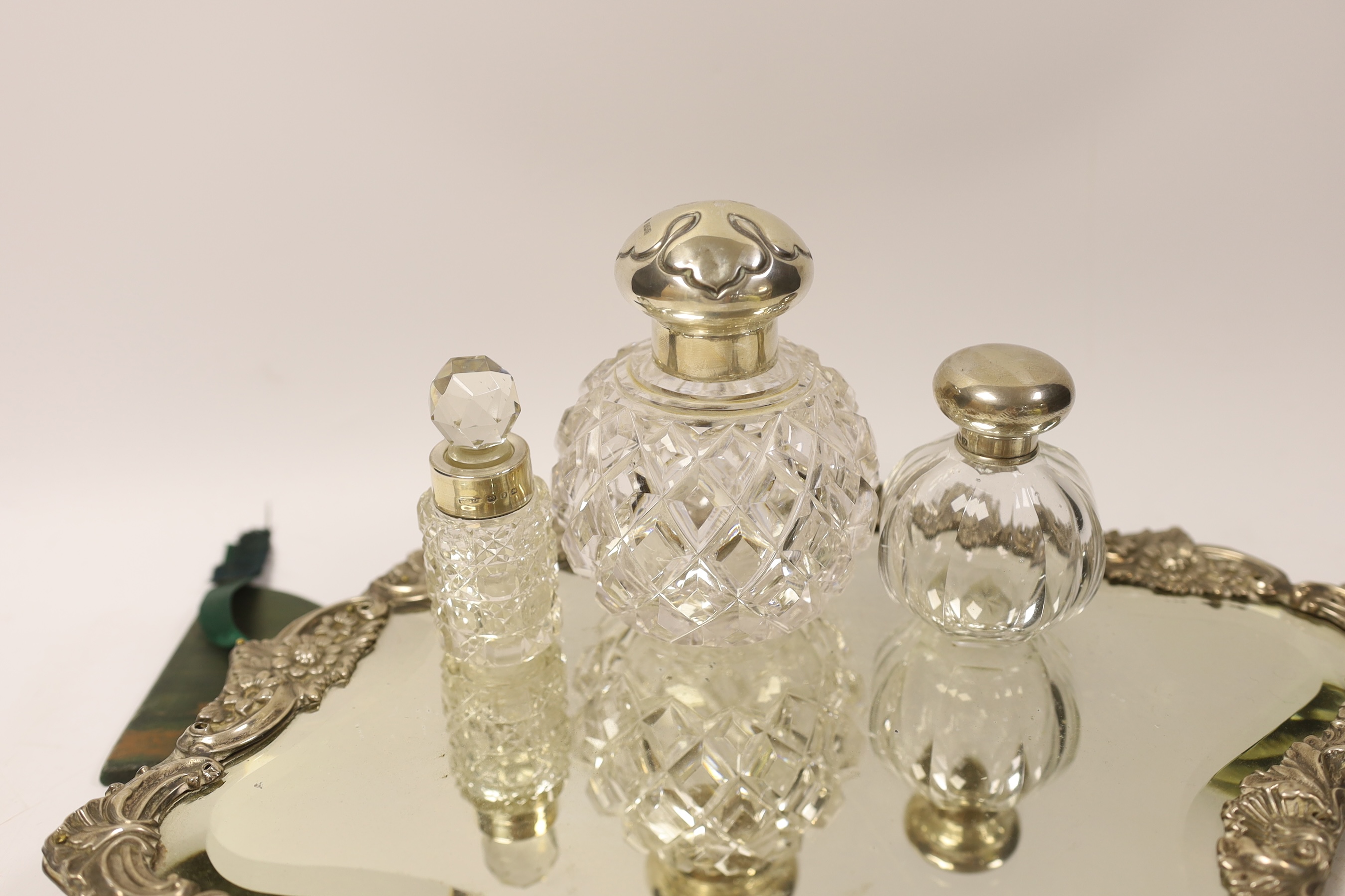 An Edwardian silver mounted easel mirror, Sheffield, 1902 (a.f.), together with three assorted silver mounted glass scent bottles.